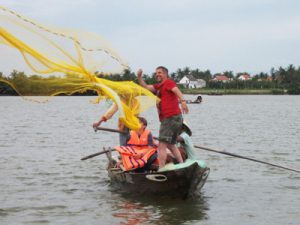 Casting fishing net from rounded bamboo boat